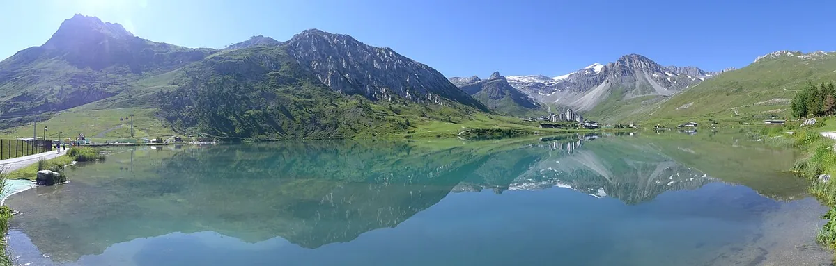 Summer panorama of Lac de Tignes and the surrounding mountains, looking south-east (2018).